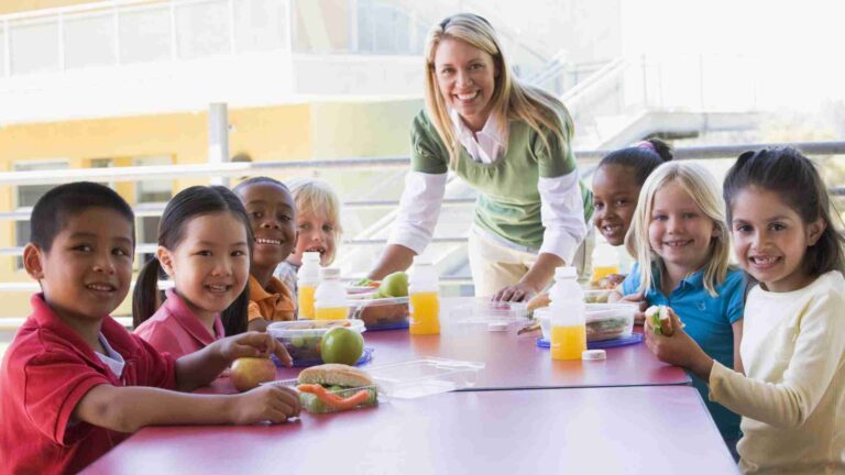 Classroom with children and an educator visibly managing snacks safely.